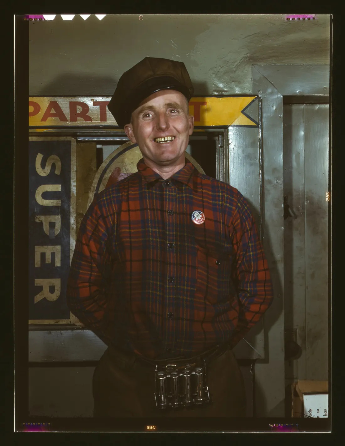 A smiling garage mechanic in a plaid shirt, 1943